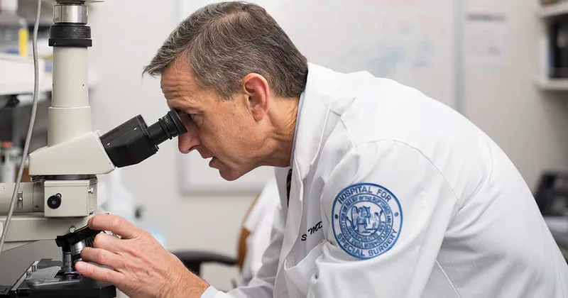 A physician examining a sample with a microscope